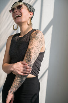 Happy outstanding tattooed girl laughing.