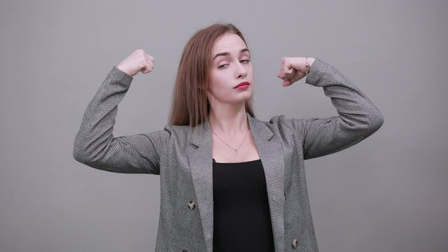 Feels proud have strength, shows great power, raises arms to show muscles confident in victory, looks strong and independent, flexing arm, facial expressions, feelings, attitude, life perception