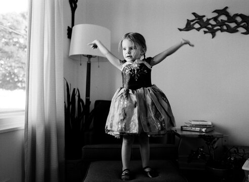 black and white photo of little girl playing dress up