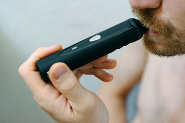 Young man with electronic cigarette in his hand