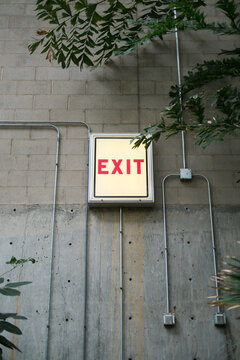 Exit sign with red letters on gray wall