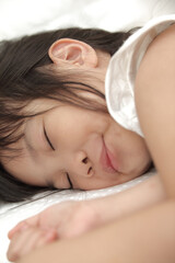 Obraz na płótnie Canvas little girl sleeping on the bed