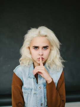 Model holding finger on lips