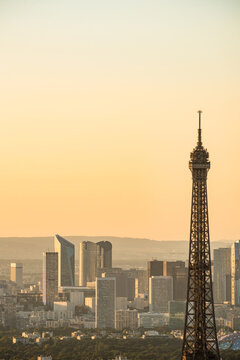 Eiffel Tower at sunset with La Defense skyline at background