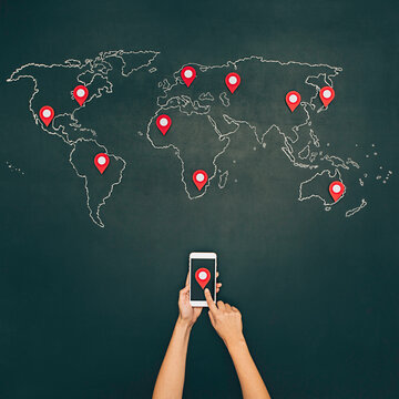 Internet search with mobile phone. World map on chalkboard with pins.
