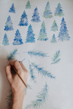 Crop person drawing fir trees