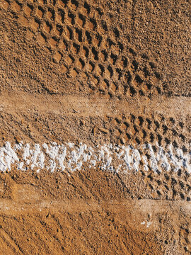 Close up of white boundary marks and tire tracks on baseball field