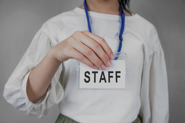 The person who shows the staff card. Staff, office workers, staff, recruitment, temporary staffing, event staff, part-time jobs, etc.  スタッフカードを見せる人。スタッフ、社員、館員、募集、派遣社員、イベントスタッフ、アルバイトなど - obrazy, fototapety, plakaty