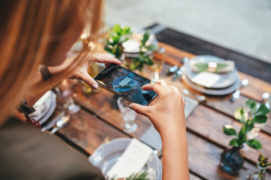 Woman Taking A Photo of Decorated Dinner Table