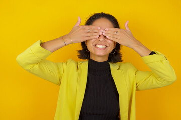 Young hispanic businesswoman wearing casual turtleneck sweater and jacket covering eyes with hands smiling cheerful and funny. Blind concept.