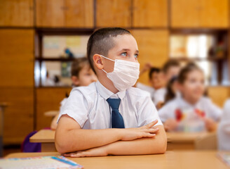 Positive kids sitting and listening teacher in elementary school class