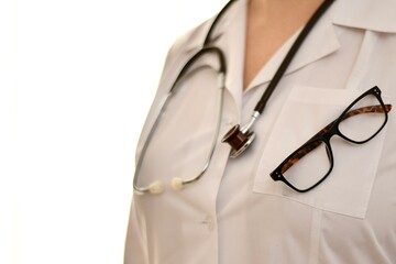 The doctor is a woman, closeup, a fragment of the breast in a white robe with glasses and a hanging...