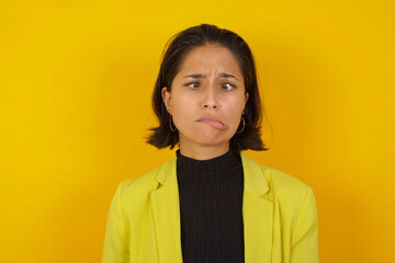 Fototapeta premium Young hispanic businesswoman wearing casual turtleneck sweater and jacket making grimace and crazy face, screaming out of control, funny lunatic expressing freedom and wild.