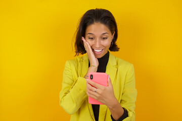 Young hispanic businesswoman wearing casual turtleneck sweater and jacket holding in hands cell reading sms using new app 5g