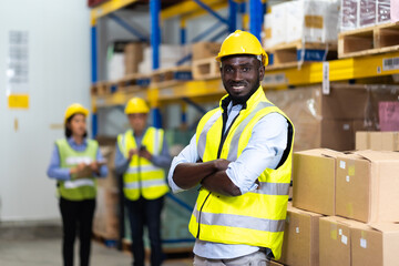 middle aged African American warehouse worker preparing a shipment in large warehouse distribution...