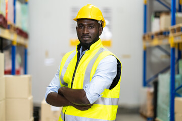Portrait of middle aged African American warehouse worker in large warehouse distribution centre.