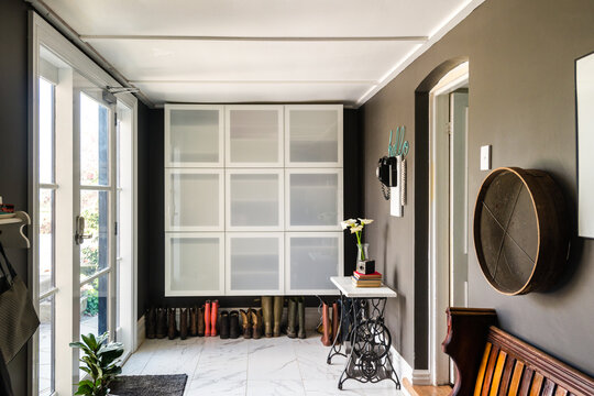mudroom with hanging cupboards and gumboots