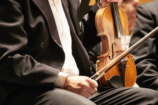 Closeup of violinist's instrument at a symphony