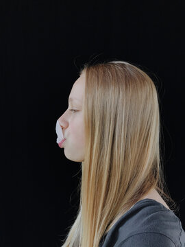 Teenage girl blowing bubble gum bubble