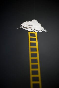 Looking up at a yellow ladder and storm cloud