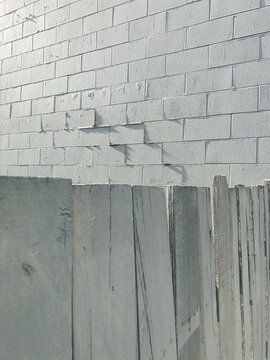 Old wood fence in front of building wall