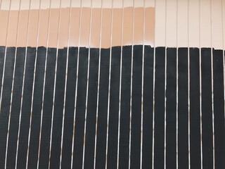 Painted beige and black wood panel wall, covering graffiti