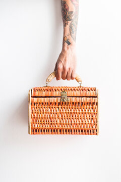 Tattooed arm with wicker case