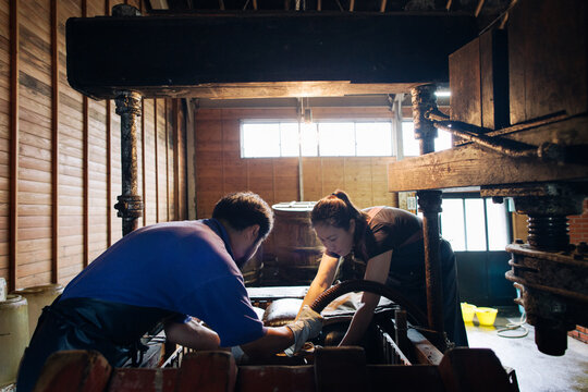 Young Japanese Man and Woman at Work in Traditional Factory