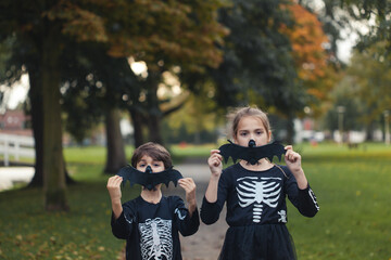 Brother and sister holding a fake bat for halloween