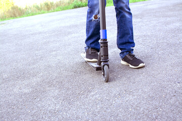 Close-up - feet of a boy on a scooter. Active rest, healthy lifestyle
