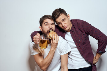 Two cheerful friends drinking beer drunk fun lifestyle communication light background