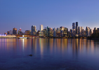 Fototapeta na wymiar Blue hour cityscape view of Vancouver Downtown from the sea wall in Stanley Park