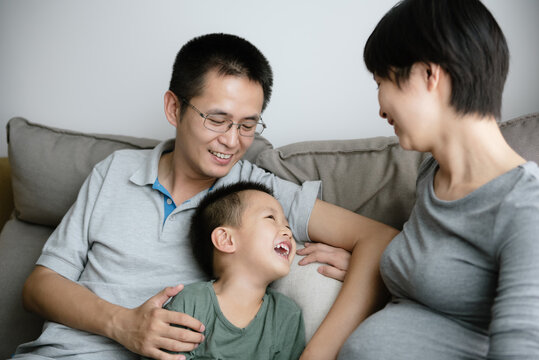Little boy] with dad and pregnant mom at home