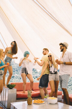 Group of friends drinking cocktails and having fun outdoors