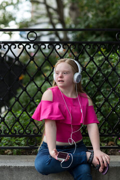 Girl with down syndrome listening to music.