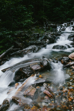 Gradually Cascading Waterfall Along Clear Stream In Green Forest