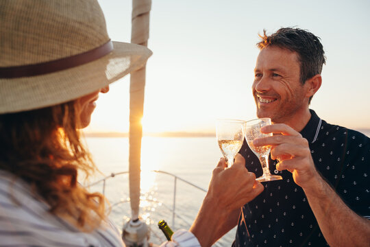 Lovely mature couple drinking cava on sailboat.