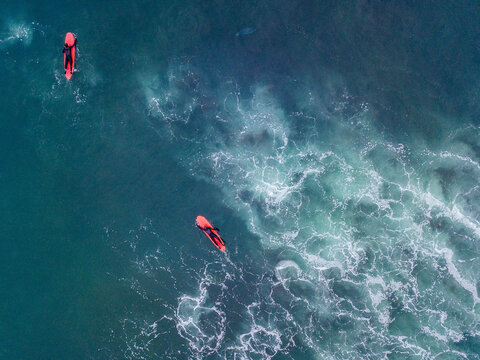 Surfers Floating On Ocean