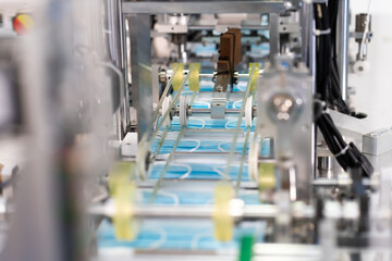 Machines are working for producing masks in a sterile factory. Production of medical masks. process of manufacturing a mask