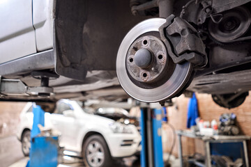 Closeup disc brake of the vehicle for repair. shot wheel, the tool for loosening the nuts. internal...