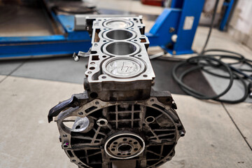 Fototapeta premium New pistons and cylinder head of engine block vehicle. Motor capital repair. Sixteen valve and four cylinder. Car service concept. The job of a mechanic. Old and new pistons.