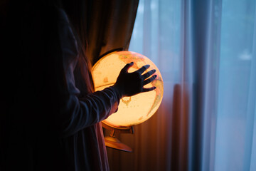 Crop woman holding glowing globe