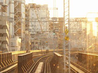 夕焼け色に染まる電車のレールと架線
