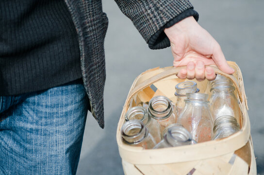 man carrying basket of empty milk bottles