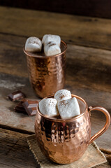 The dessert food vintage style : The Marshmallow with hot chocolate in copper cup on the wooden table. Background copy space for copy text