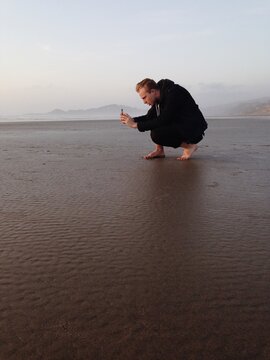 Man Taking Photos on Beach