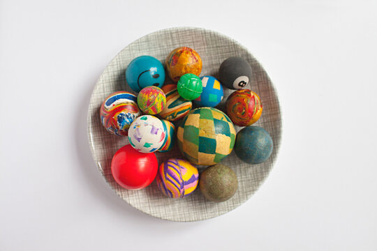 a collection of old retro rubber bounce balls in a dish