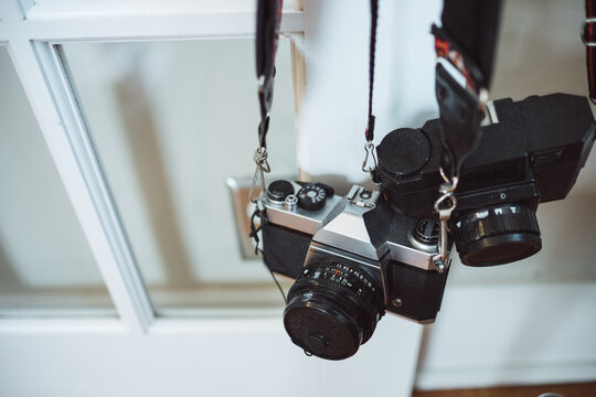 Two cameras hanging on a door knob