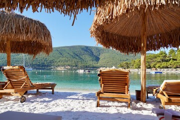 Bodrum, Turkey - August 2020: Beach with white sand, pine trees, clear blue sky, bamboo umbrellas. Relax Luxury Tourism conception, Vacations and Summer Concept