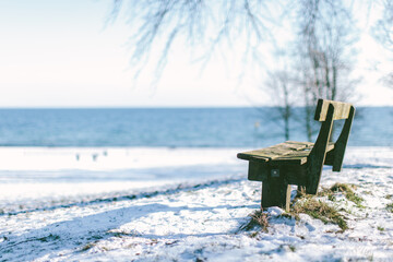 Empty bench in snowy landscape